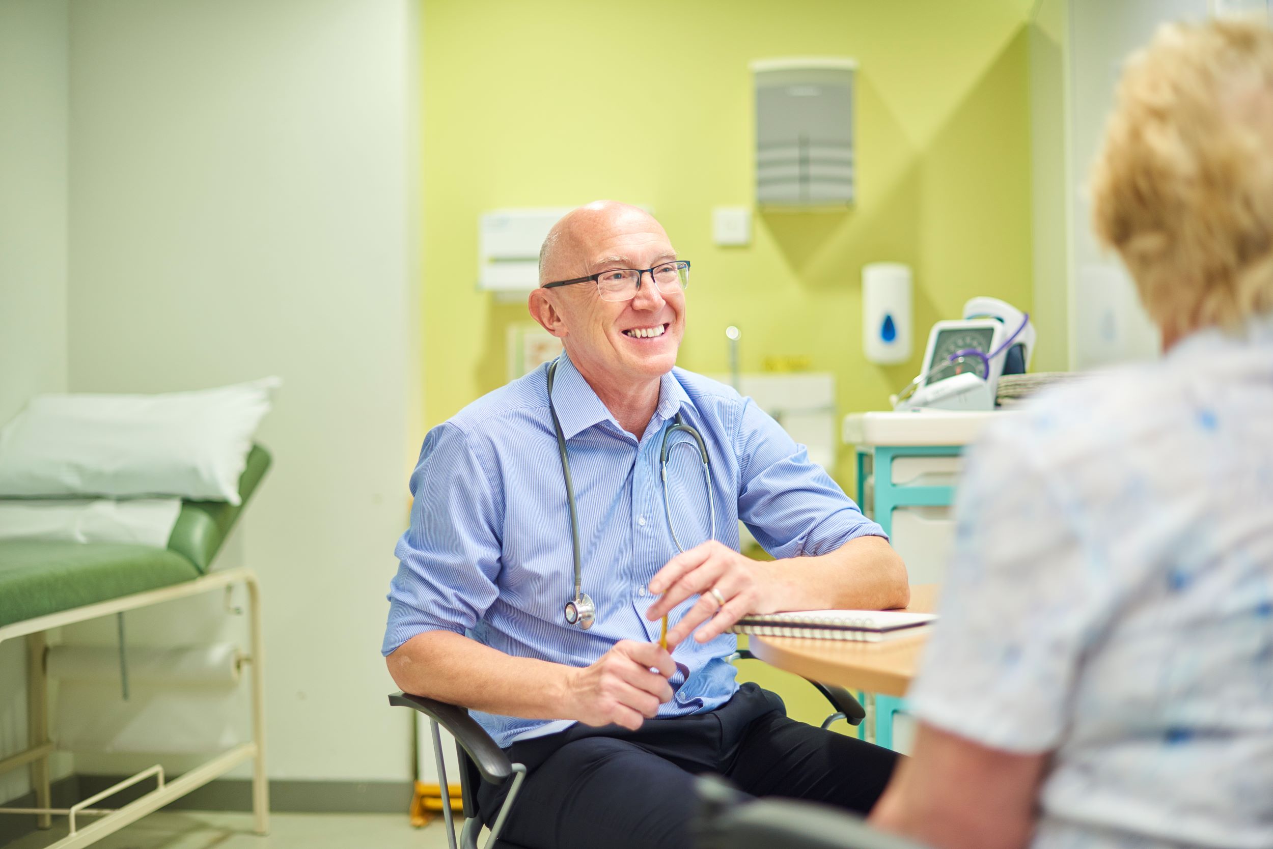 A photo of the GP speaking to a patient and smiling